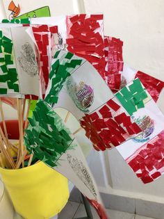 a bunch of flags that are sitting in a vase on the floor with sticks sticking out of them