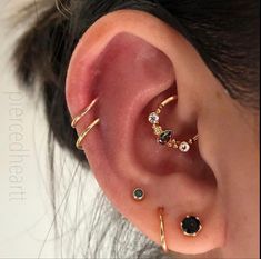 an ear with three different types of piercings on top of it, and one in the middle