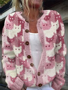 a woman wearing a pink and white cardigan sweater with cats on the front,