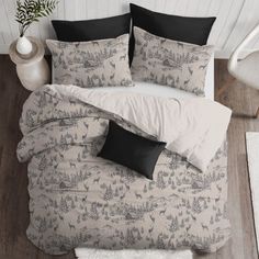 a bed with black and white pillows on top of it