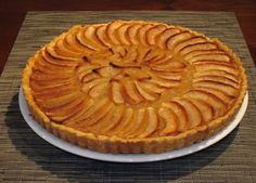 an apple pie on a white plate sitting on a place mat