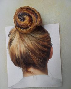 a woman's head with a pastry on top of her head, in front of a piece of paper