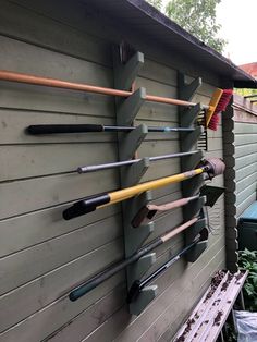 there are many different types of garden tools on the wall in front of this house