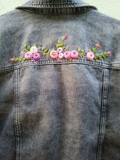 a denim jacket with flowers embroidered on the back