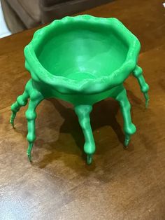 a green plastic bowl sitting on top of a wooden table