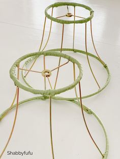 three circular wire sculptures sitting on top of a white floor next to each other in a room