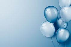 blue and white balloons floating in the air on a light blue background with space for text