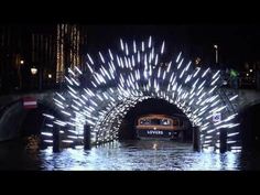 a car driving through a tunnel with lights on it's sides in the water