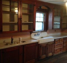 an empty kitchen with wooden cabinets and white sink