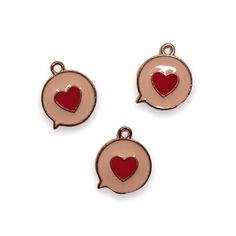 three charms with hearts in the shape of speech bubbles, one red and one pink