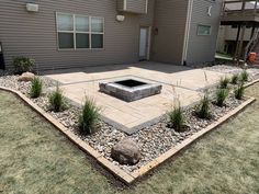 a patio with rocks and plants in the middle