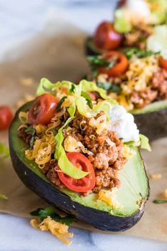 two stuffed avocados filled with meat and vegetables