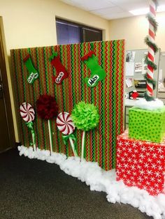 some candy canes wrapped in green and red paper with christmas decorations on them next to a wall