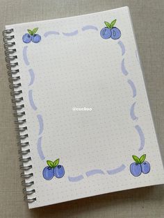 an open notebook with blue cherries on it