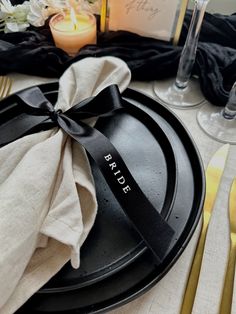 a black plate with the name pride on it and a napkin tied around its edge