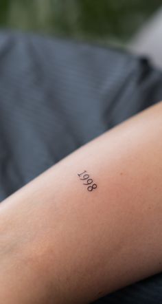 a person with a small tattoo on their arm that says love and is sitting down