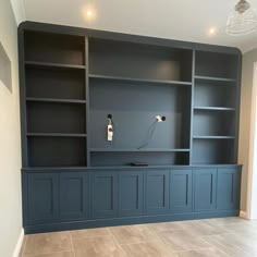 an empty room with built in bookshelves and tile flooring on the walls