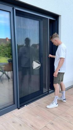 a man standing in front of a sliding glass door