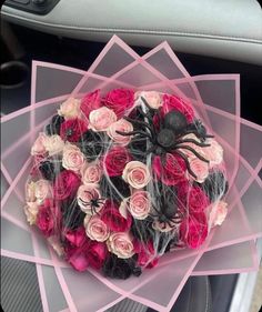 a bouquet of flowers in the center of a car seat with spider decorations on it