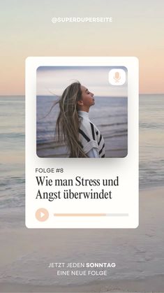 a woman standing on top of a beach next to the ocean with her hair blowing in the wind