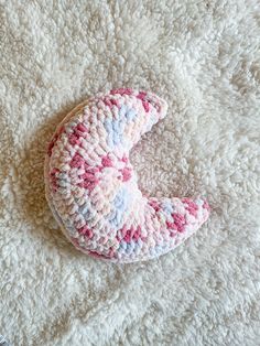 a crocheted stuffed animal laying on top of a white blanket