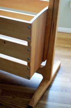 a wooden crib with no mattress on the floor