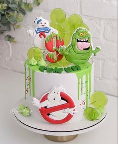 there is a cake decorated with monsters on the top and green icing around it