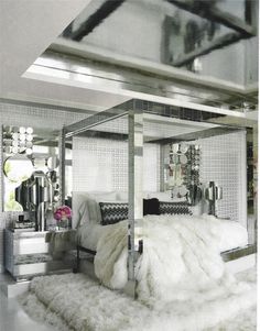 a bedroom with mirrored walls and white fur rugs