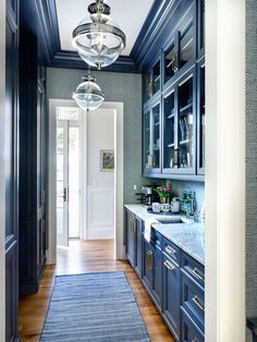 a hallway leading to a kitchen with blue cabinets