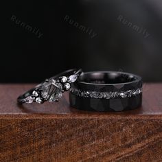 two wedding rings sitting on top of a wooden table next to each other with diamond accents