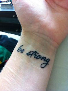 a woman's wrist tattoo with the words be strong on it