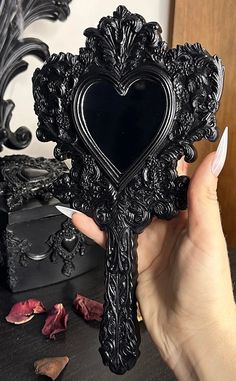 This absolute show-stopping hand mirror is a cast replica of our original art piece titled “Vanity Valentine”. It is hand-cast with museum-quality matte black resin. Entire measurements: 25cm long x 13.5cm wide x 1.5cm deep. Mirror measurements: 7.5cm long x 6.25cm wide. Please note - this item is a human-created artisan product. It is a cast of a hand-carved sculpture, no laser engravers or robots were used to make any of these items, therefore they will contain “signs of life”. These include s Gothic Mirror, A Touch Of Darkness, Touch Of Darkness, Carved Sculpture, Laser Engravers, Trick Or Treat Studios, Goth Home, Goth Home Decor, Goth Decor