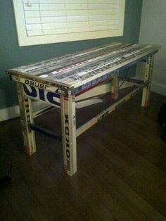 a table made out of skis in the middle of a room with hard wood flooring