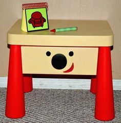 a small wooden table with a toy koala on it's side and a notepad sitting on top