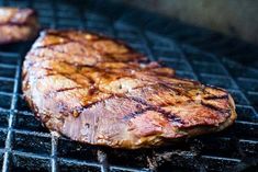 two steaks are cooking on the grill