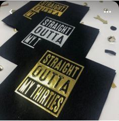 three black and gold coasters sitting on top of a white table next to confetti