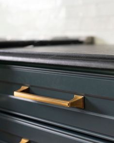 a black and gold dresser with brass handles