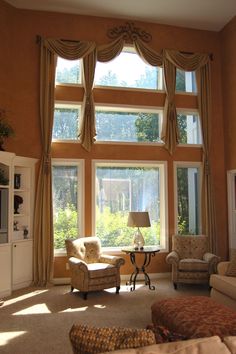 a living room filled with furniture and large windows