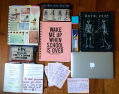 an apple computer sitting on top of a wooden table next to notebooks and books