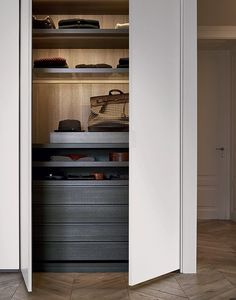 an open closet with many items on the shelves and in between it is a wooden floor