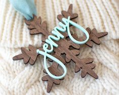 two wooden ornaments with the word love spelled out in blue on top of a white sweater