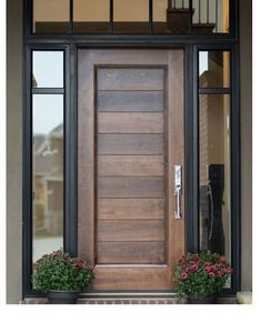 a wooden door with two planters on the side