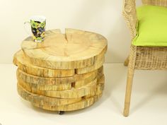 a stack of wooden stools sitting next to a table with a cup on it