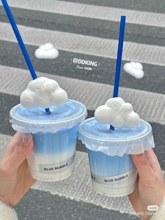 two people holding up cups with clouds on them