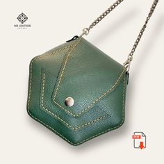 a green leather purse with chain hanging from it's front pocket on a white background