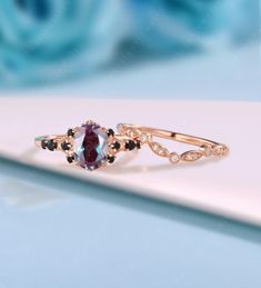 a close up of a ring with an oval shaped stone and black diamonds on it