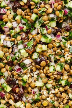 a close up view of a salad made with chickpeas, cucumbers and other vegetables