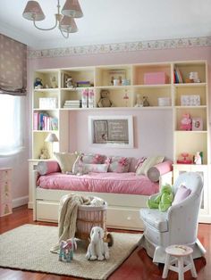 a child's bedroom decorated in pink and white with bookshelves on the wall