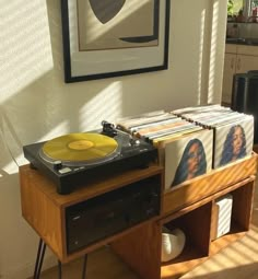 a record player sitting on top of a wooden table in front of a framed photo