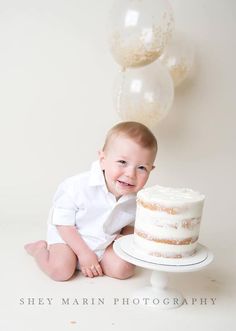 a baby sitting in front of a cake